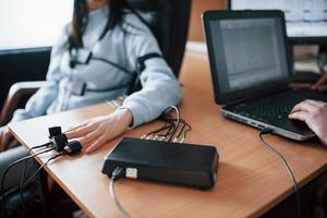 Fidelity verification. Girl passes lie detector in the office. Asking questions. Polygraph test photo