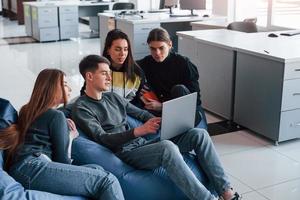 Clean and spacious room. Group of young people in casual clothes working in the modern office photo