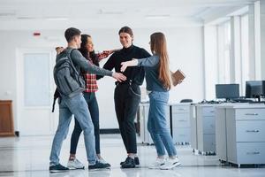 Ready for the nice working day. Group of young people walking in the office at their break time photo