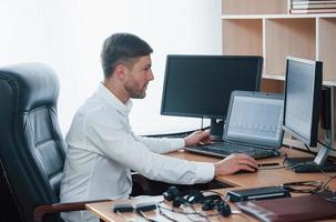 Ready to work. Polygraph examiner works in the office with his lie detector's equipment photo