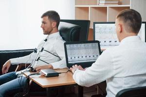 Why you steal that car. Suspicious man passes lie detector in the office. Asking questions. Polygraph test photo