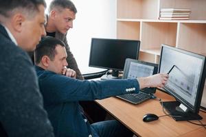 Three people. Polygraph examiners works in the office with his lie detector's equipment photo