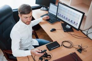 Just a minute and we are ready. Polygraph examiner works in the office with his lie detector's equipment photo