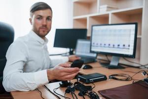 You can trust us. Polygraph examiner works in the office with his lie detector's equipment photo