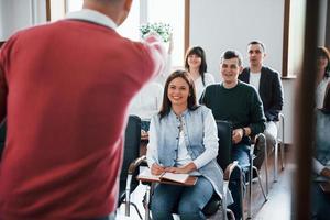 Funny coach. Group of people at business conference in modern classroom at daytime photo