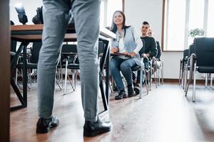 Happy to see you all here. Group of people at business conference in modern classroom at daytime photo