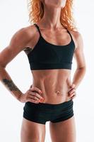 Redhead female bodybuilder is in the studio on white background photo