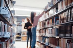 Blurred photo. Multiracial students in the library searching for the information together photo