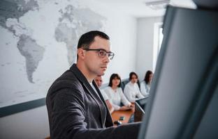 Take a look at this graph. Group of people at business conference in modern classroom at daytime photo