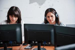 Photo of two employees. Young people working in the call center. New deals is coming