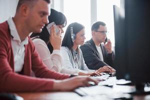 Daily routine job. Young people working in the call center. New deals is coming photo