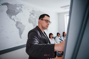 Serious man. Group of people at business conference in modern classroom at daytime photo