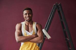 Standing with arms crossed. Young african american worker in the yellow uniform have some job photo