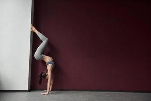 mujer deportiva en acción. chica con buen tipo de cuerpo físico tiene ejercicios en la habitación espacial foto