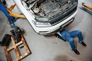 Artificial lighting. Employee in the blue colored uniform works in the automobile salon photo