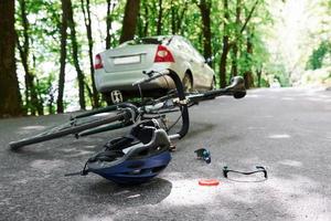 llame a una emergencia. bicicleta y accidente automovilístico de color plateado en la carretera en el bosque durante el día foto