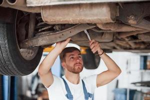 Rusty car. Employee in the blue colored uniform works in the automobile salon photo