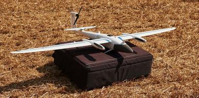 Modern small remote controlled white colored plane on black bag. Ready to fly photo