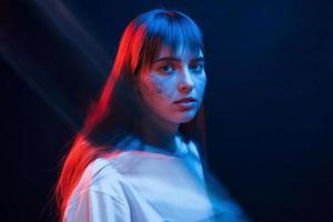 Cute make up. Studio shot in dark studio with neon light. Portrait of young girl photo