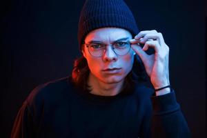 Smart person. Studio shot in dark studio with neon light. Portrait of serious man photo