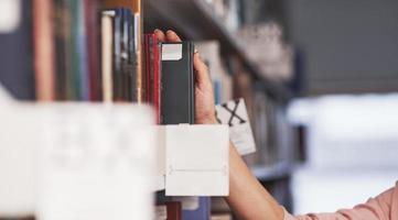 Taking black book. Girl searching for some information in the library photo