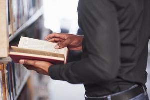 Turning pages. African american man in the library searching for some information in the books photo