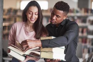 Deja que te ayude. estudiantes multirraciales en la biblioteca buscando la información juntos foto