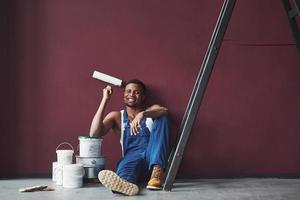 Job well done. Young african american worker in blue uniform have a break photo