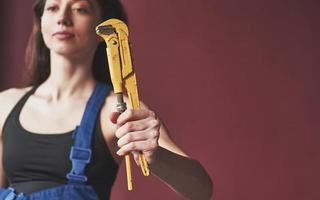 Universal wrench. Young housewife decided to glue wallpaper in her new house in the room photo