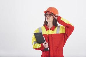 Let's do this job. Brunette woman in orange and yellow uniform stands against white background in the studio photo