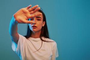 In white shirt. Studio shot indoors with neon light. Portrait of beautiful young girl photo