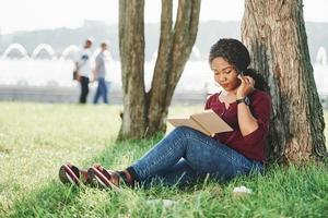 Such a beautiful place. Cheerful african american woman in the park at summertime photo