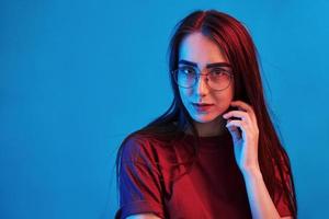 Smart person. Studio shot indoors with neon light. Portrait of beautiful young girl photo