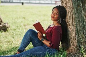 Side view. Cheerful african american woman in the park at summertime photo