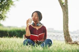 Calm and quiet. Cheerful african american woman in the park at summertime photo