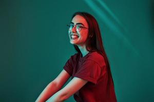 Clean skin. Studio shot indoors with neon light. Portrait of beautiful young girl photo