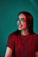 Have good day. Studio shot indoors with neon light. Portrait of beautiful young girl photo