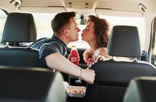 Love and food. Beautiful people is in the modern car at their weekends photo