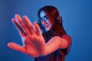 Feel the rhythm. Studio shot indoors with neon light. Portrait of beautiful young girl photo