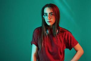 Caucasian ethnicity. Studio shot indoors with neon light. Portrait of beautiful young girl photo