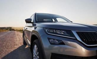 coche nuevo y moderno aparcado en la carretera lateral en el campo durante el día foto