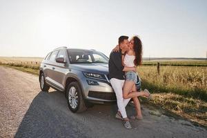 Lovely couple near their new modern car at weekend time photo