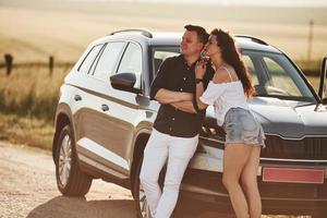 Quiet atmosphere. Lovely couple near their new modern car at weekend time photo