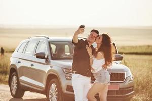 Kiss in the cheek. Lovely couple in their new modern car at weekend time photo