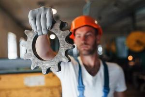 Holds in one hand. Man in uniform works on the production. Industrial modern technology photo