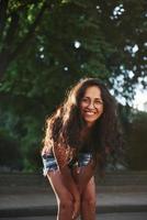 hermosa chica con gafas. hermosa mujer con cabello negro rizado pasar un buen rato en la ciudad durante el día foto