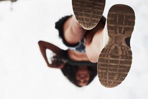 vista de cerca de los zapatos. mujer con ropa informal se para en el vidrio durante el día foto