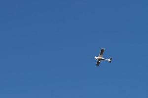 Biplane flying high in the blue sky at sunny day. Speed and energy photo