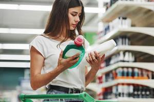 Holds product. Female shopper in casual clothes in market photo