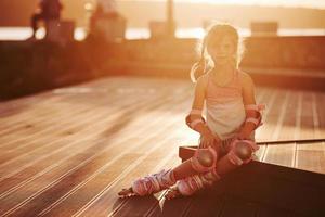 niño lindo feliz con sus patines. increíble luz del sol foto